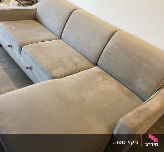 ספה בהירה עם כריות בסלון ביתי